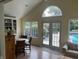 Sunroom with tile floors and views of the swimming pool through the French doors and windows at 9510 Copley Dr, Indianapolis, IN 46260