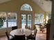 Bright sunroom featuring large windows overlooking the pool, and a dining table and comfortable seating area at 9510 Copley Dr, Indianapolis, IN 46260