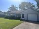 Well-kept single-story home featuring an attached garage, and front yard under a sunny sky at 9533 Burrwood Ct, Indianapolis, IN 46235