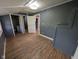 Bedroom with wood-look floors and blue-gray paint, with an entry visible to another room at 9712 N Price St, Knightsville, IN 47857