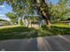 A quaint home nestled under a large tree, showcasing its inviting front exterior and green surroundings at 9712 N Price St, Knightsville, IN 47857