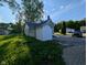 View of home's rear exterior featuring a garage or storage area, green lawn and bright sky at 9712 N Price St, Knightsville, IN 47857