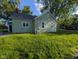Back of home featuring light green siding and windows, complemented by a well-kept lawn at 9712 N Price St, Knightsville, IN 47857