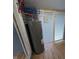 Utility room featuring the hot water heater, pipes, and access to the exterior at 9712 N Price St, Knightsville, IN 47857