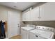 Bright laundry room featuring white cabinets and modern washer and dryer at 101 Edgewater Dr, Noblesville, IN 46062