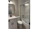 Modern bathroom featuring a sink, a toilet, and a shower-tub combo with a glass door at 10328 Central Ave, Carmel, IN 46280