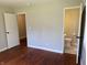 Bedroom with hardwood floors and views of a bathroom and open doorway at 10328 Central Ave, Carmel, IN 46280