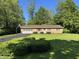 Charming brick home with a well-manicured lawn and an attached garage, nestled amongst mature trees at 10328 Central Ave, Carmel, IN 46280