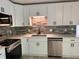A modern kitchen featuring white cabinets, stainless steel appliances, and a stylish tile backsplash at 10328 Central Ave, Carmel, IN 46280