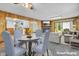 The staged living room features a brick fireplace, wood paneling and plush seating for a warm, inviting atmosphere at 10346 Wilson Rd, Brownsburg, IN 46112