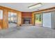 Cozy living room features wood paneling, fireplace, and sliding glass doors to the backyard at 10346 Wilson Rd, Brownsburg, IN 46112