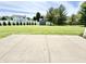 Spacious backyard featuring a large, well-maintained lawn, mature trees, a shed, and a concrete patio at 10847 Woodlook Ln, Indianapolis, IN 46239