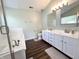 Bathroom featuring double vanity, hard surface floors, soaking tub, and a separate glass enclosed shower at 10847 Woodlook Ln, Indianapolis, IN 46239