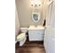 Cozy half bath with a modern vanity, oval mirror, and stylish fixtures at 10847 Woodlook Ln, Indianapolis, IN 46239
