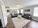 Comfortable living room with a large sectional sofa, plush rug, and open access to the kitchen and outdoor spaces at 10847 Woodlook Ln, Indianapolis, IN 46239
