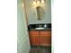 Modern bathroom features a dark vanity with updated fixtures and a large, round mirror at 12860 University Cres # 1B, Carmel, IN 46032