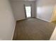 Neutral bedroom with gray carpet, white trim, and a window for natural light at 12860 University Cres # 1B, Carmel, IN 46032