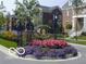 Elegant gated entrance to the village, featuring beautiful landscaping and brick homes at 12860 University Cres # 1B, Carmel, IN 46032