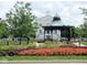 Charming town square with a gazebo, lush landscaping and a stately building in the background at 12860 University Cres # 1B, Carmel, IN 46032