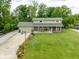 Aerial view displays a lush front yard and long driveway leading to a charming two-story home with inviting porch at 12920 N Oakhaven Dr, Camby, IN 46113