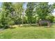 Expansive backyard with a shed, mature trees, and lush green grass, offering ample space for outdoor activities at 12920 N Oakhaven Dr, Camby, IN 46113