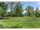 Expansive backyard with a shed, mature trees, and lush green grass, offering ample space for outdoor activities at 12920 N Oakhaven Dr, Camby, IN 46113
