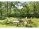 Backyard firepit surrounded by chairs creating an outdoor space for entertaining in a lush, green setting at 12920 N Oakhaven Dr, Camby, IN 46113