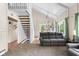 Bright living room featuring vaulted ceilings, a staircase, and a comfortable gray sofa at 12920 N Oakhaven Dr, Camby, IN 46113