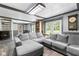 Spacious living room with a large gray sectional sofa, a bookshelf and access to the backyard at 12920 N Oakhaven Dr, Camby, IN 46113