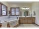 Bright bathroom featuring a soaking tub, vanity, and a large window with blinds at 1344 S Fox Paw Dr, New Palestine, IN 46163