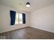 Bedroom features laminate flooring, natural light, neutral paint, and blue curtains at 1414 Dowell St, Greenwood, IN 46143