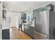 Well-lit kitchen featuring stainless steel appliances, dark green cabinets, and hardwood floors at 1421 S New Jersey St, Indianapolis, IN 46225