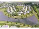 Serene aerial view of homes encircling a lake with mature trees and manicured lawns in a picturesque suburban setting at 14353 Chariots Whisper Dr, Carmel, IN 46074