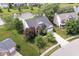 Aerial view of a brick home with a well-manicured lawn and mature trees in a suburban neighborhood at 14353 Chariots Whisper Dr, Carmel, IN 46074
