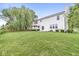 Large backyard with lush green lawn, a red umbrella offering shade, and mature trees for added privacy at 14353 Chariots Whisper Dr, Carmel, IN 46074