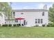 Expansive backyard with a patio set under a red umbrella, with a lush lawn, and mature trees at 14353 Chariots Whisper Dr, Carmel, IN 46074