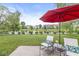 Backyard patio featuring an umbrella-covered table and chairs overlooking a tranquil pond at 14353 Chariots Whisper Dr, Carmel, IN 46074