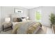 Well-lit bedroom with a large window, neutral walls, and a comfortable bed with decorative pillows at 14353 Chariots Whisper Dr, Carmel, IN 46074