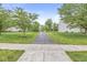 A view of the driveway entrance lined with mature trees leading to the property at 14353 Chariots Whisper Dr, Carmel, IN 46074