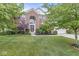 Traditional brick home boasting a covered entrance, arched window, and professionally landscaped front yard at 14353 Chariots Whisper Dr, Carmel, IN 46074