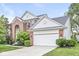 Charming brick and siding home featuring an attached two-car garage and landscaped front yard at 14353 Chariots Whisper Dr, Carmel, IN 46074