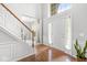 Bright and inviting foyer showcasing hardwood floors, staircase, and natural light at 14353 Chariots Whisper Dr, Carmel, IN 46074
