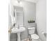 A tidy half bathroom features a pedestal sink and toilet at 14353 Chariots Whisper Dr, Carmel, IN 46074
