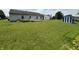 Expansive backyard view featuring a lush lawn, storage shed, fire pit, and home exterior at 1562 Prairieview Ln, Greenfield, IN 46140