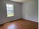 This bedroom features warm wood flooring and a bright window, ideal for a cozy retreat at 1562 Prairieview Ln, Greenfield, IN 46140