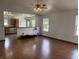 Open-concept living space with hardwood floors connecting to the kitchen and dining areas at 1562 Prairieview Ln, Greenfield, IN 46140