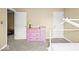 Cozy bedroom showcasing a pink dresser, neutral carpet, and bright lighting at 17841 Grassy Knoll Dr, Westfield, IN 46074