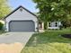 Charming single-Gathering home featuring a gray garage door, lush lawn, and mature trees at 17841 Grassy Knoll Dr, Westfield, IN 46074