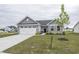 Charming single-Gathering home showcasing a well-manicured lawn, two car garage, and stone accents at 1863 River Birch Dr, Greenfield, IN 46140