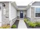Inviting front entrance with stone details, flowerbeds, and a modern navy blue door at 1863 River Birch Dr, Greenfield, IN 46140